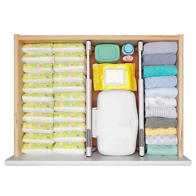 Drawer divided into sections with diapers, wipes, and baby clothes using the OXO Tot Drawer Divider - White.