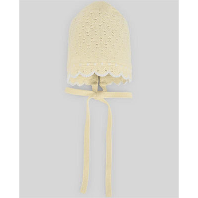 Chalk pink and white knitted baby hat with scalloped edges and ties at the chin.
