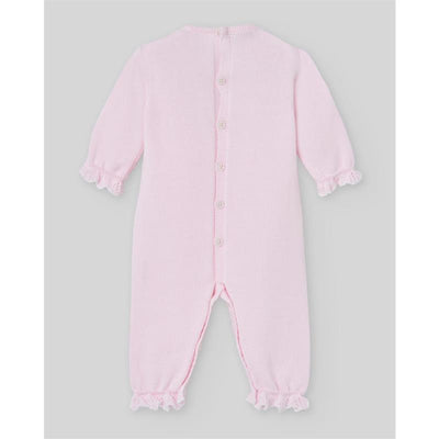 Knit newborn romper in chalk pink and white with long sleeves, ruffled cuffs, and button closure down the back.