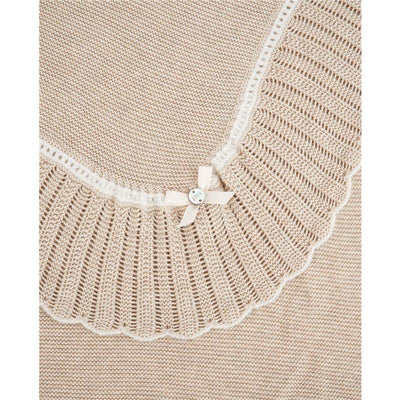 Knit newborn shawl in light brown and cream, featuring a scalloped edge and a decorative ribbon with a button.