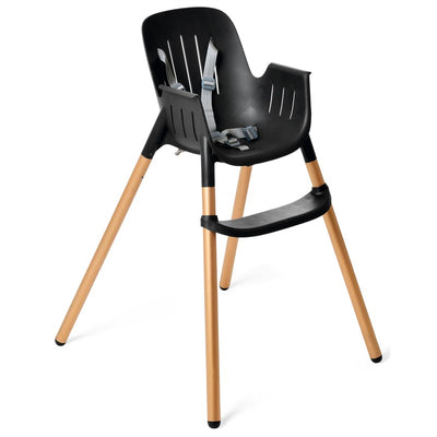 High chair in black with gold legs, featuring a safety harness and a sleek, modern design.