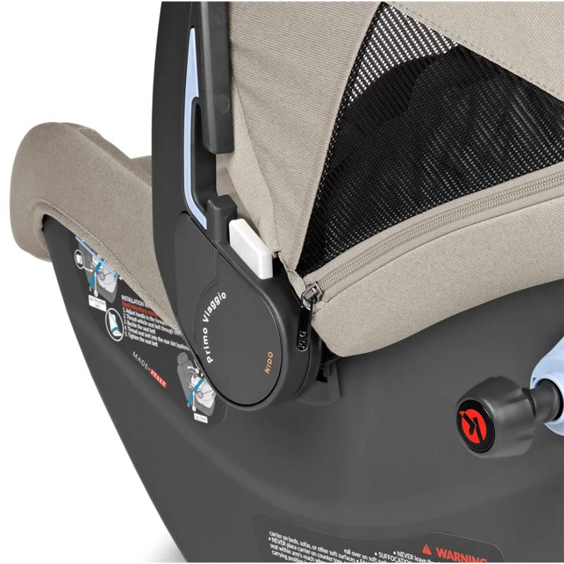 Peg Primo Viaggio Nido Infant Car Seat in Astral color, featuring safety harness, mesh panel, and detailed instructional labels.