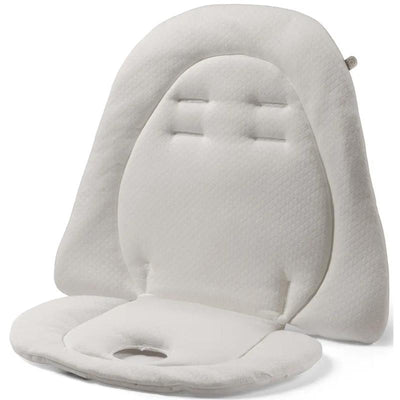 Reversible baby cushion by Peg Perego, featuring a soft white fabric with small beige polka dots and a cut-out for safety.