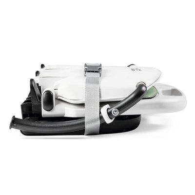 Peg Rialto Booster High Chair in Ice, shown in a folded position with a strap for secure storage.