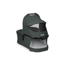 Peg Perego Ypsi Bassinet in sage green with a mesh panel, designed for infants with a protective canopy and sturdy frame.