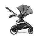 Peg Perego Ypsi Travel System in metal frame with large canopy and storage basket, showcasing sleek design and durable wheels.
