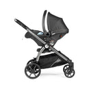 Peg Perego Ypsi Travel System in metal with a sleek black design, featuring a reclining seat and a spacious storage basket.