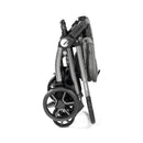 Peg Perego Ypsi Travel System in Vanilla Blend, compactly folded with large wheels and a gray fabric storage pocket.