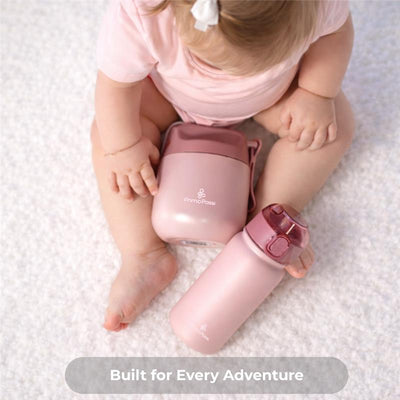 Insulated bottle and food jar in rose pink, placed near a baby sitting on a soft surface, showcasing the brand Primo Passi.