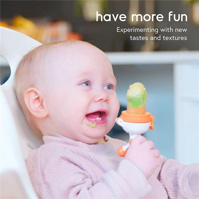 Baby happily using a Quark Fruuti Baby Fruit Feeder, exploring new tastes with a green food piece in the feeder.