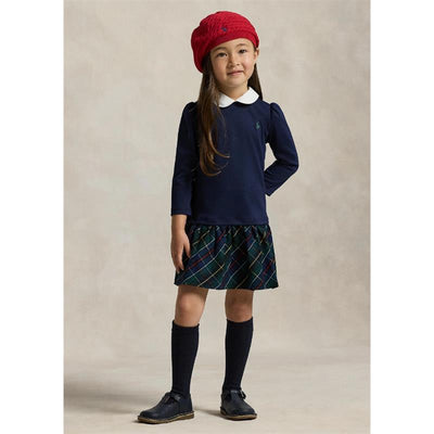 Girl wearing a navy long-sleeve collared shirt dress with a plaid skirt, casual shoes, knee-high socks, and a red beret.