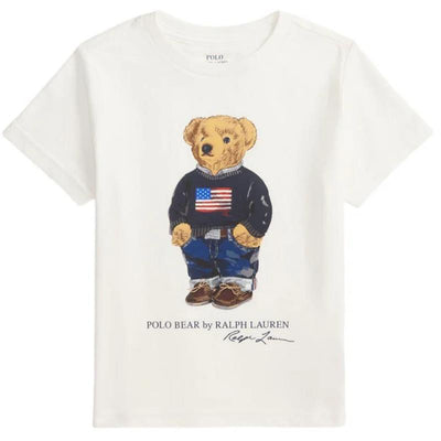 Short-sleeve white t-shirt featuring a cartoon bear in a navy sweater with an American flag and blue jeans.