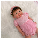 Reborn baby doll Vivienne, featuring a full silicone body, dressed in a pink outfit with floral accents.