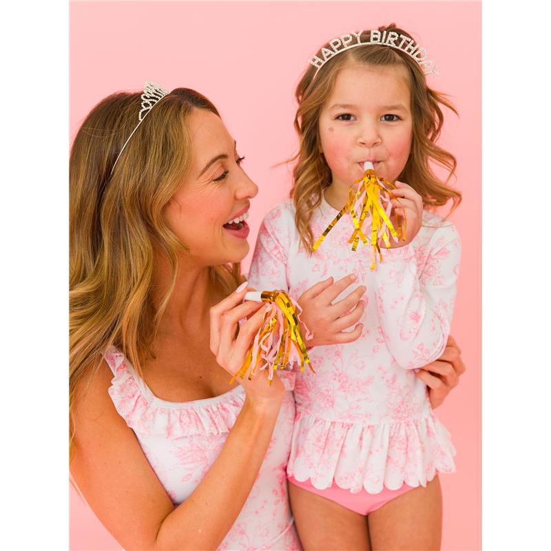 Long sleeve swimsuit set featuring a floral design on a mother and daughter celebrating with party accessories against a pink background.