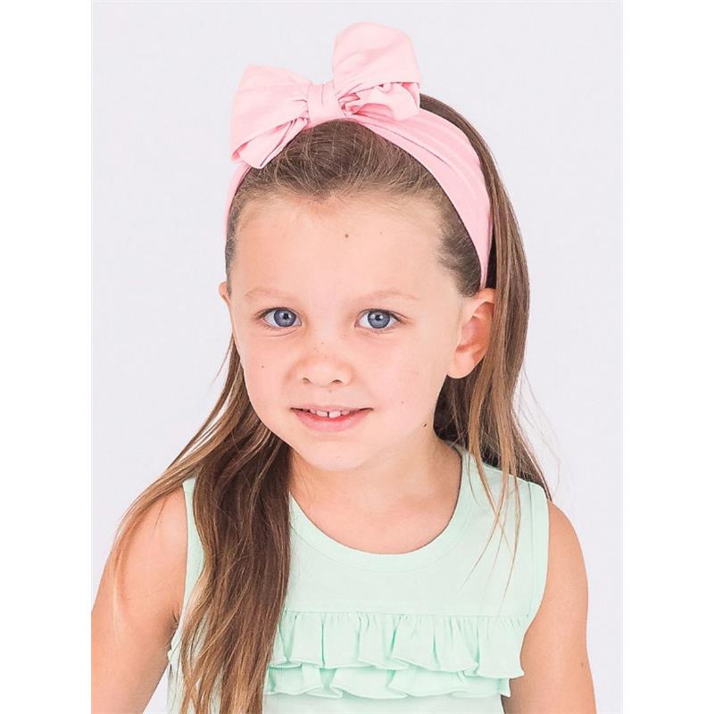 Girls pink headband featuring a large bow, worn by a child with long hair, smiling and dressed in a mint green top.