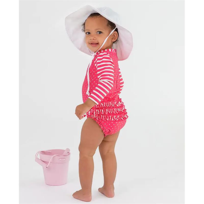 Hot pink long sleeve rash guard with white stripes and ruffled bottom, worn by a toddler holding a pink bucket.