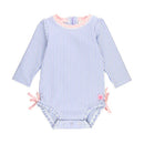 Periwinkle blue seersucker rash guard for infants, featuring long sleeves, pink trim, and bows on the sides.