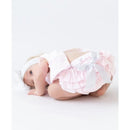 Baby girl wearing a pink seersucker swing top and bloomer set with ruffles and a bow, crawling on the floor.