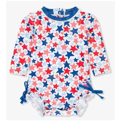 Long sleeve one-piece rash guard in white featuring a vibrant star pattern in red, blue, and pink.