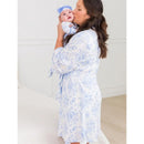 Mother in a blue floral maternity robe kisses her baby, who is dressed in matching blue with a bow, showcasing a sweet moment.