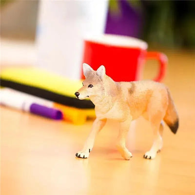 Coyote toy figurine standing on a desk, detailed with realistic colors and features, surrounded by office items.
