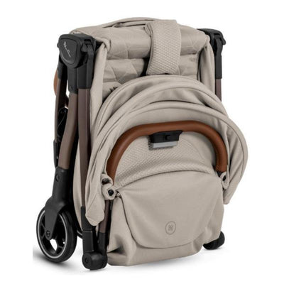 Clic Lightweight Stroller in Latte color, folded with a soft, textured fabric and brown handle, showcasing compact design.