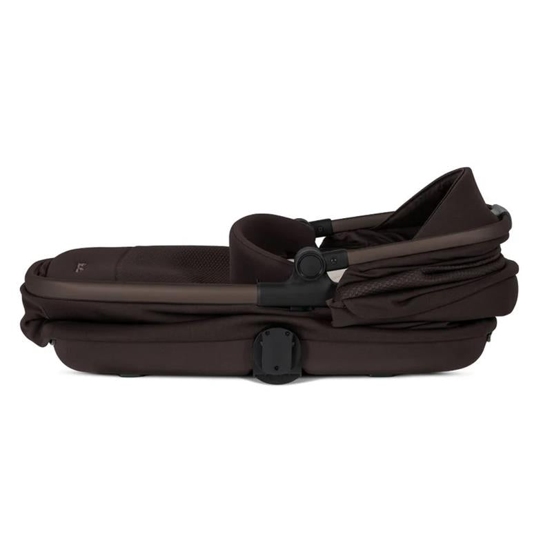 Silver Cross Reef 2 Folding Bassinet in Ganache color, featuring a compact design with a padded interior and carrying handle.