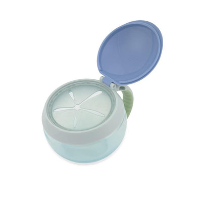 Skip Hop Baby Snack Container in dino design, with a blue lid open, featuring a clear base and a handle.