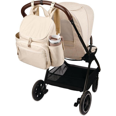Skip Hop Diaper Bag Backpack in oat color, attached to a stroller, featuring multiple pockets and a cup holder.