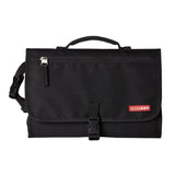 Portable black baby changing pad by Skip Hop, featuring a front zipper pocket and secure buckle closure for convenience.