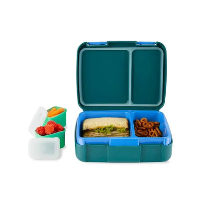 Skip Hop Spark Style Bento Box in truck design, featuring compartments with a sandwich, pretzels, and fruits in side containers.