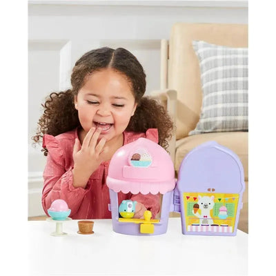 Young child playing with the Skip Hop Zoo Ice Cream Shoppe Playset, featuring a colorful ice cream stand and accessories.