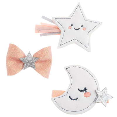 Set of three hair clips featuring a smiling silver star, a sparkly pink bow with a silver star, and a crescent moon with a star.