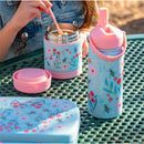Insulated stainless steel bottle with handle and floral design, alongside a matching food container, on a green table.