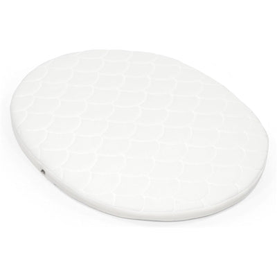 Stokke® Sleepi™ Mini Mattress in white, featuring a padded, quilted surface with an oval shape.
