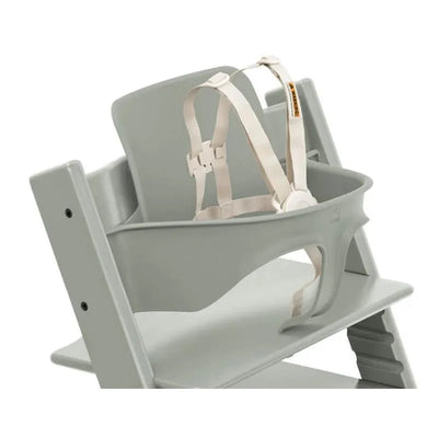 Stokke Tripp Trapp® High Chair in Glacier Green with a beige safety harness attached to the removable baby seat.