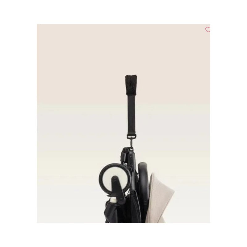 Stokke Yoyo³ stroller with a black frame and Bonpoint bundle leg rest, showing a hanging strap and wheel detail.