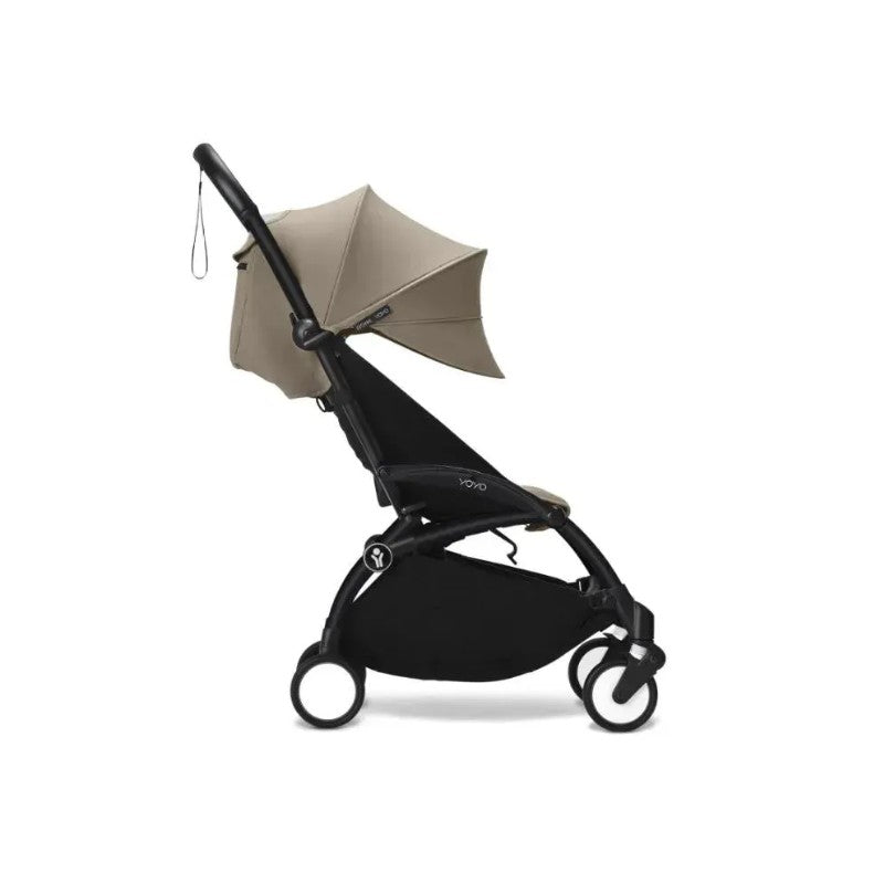 Stokke Yoyo³ stroller in black frame with taupe leg rest and canopy, designed for children 6 months and older.