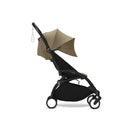 Stokke Yoyo³ stroller in black frame with toffee seat, featuring a canopy and adjustable leg rest.