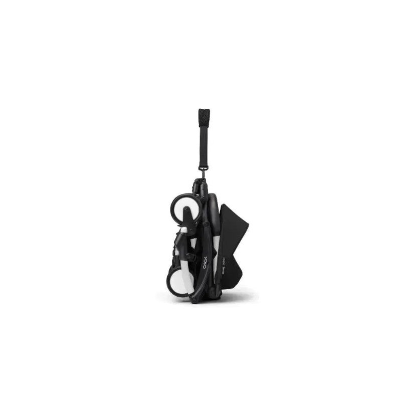 Stokke Yoyo³ stroller folded with a white frame and black bundle, featuring a leg rest and carrying strap.