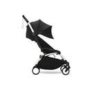 Stokke Yoyo³ stroller in black with a white frame, featuring a canopy and leg rest, designed for children 6 months and older.