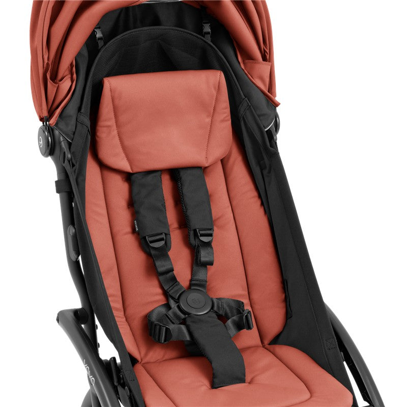 Compact Stokke Yoyo5 stroller in black frame, featuring a berry-colored seat with adjustable safety harness and headrest.