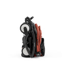 Compact Stokke Yoyo5 stroller in black frame with berry fabric, shown in a folded position.