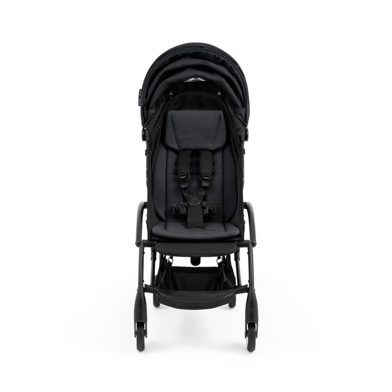 Compact black stroller with a black frame, featuring a padded seat, safety harness, and a storage basket underneath.