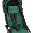 Compact Stokke Yoyo5 stroller features a black frame with a forest green seat, equipped with safety harness and padded support.