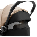 Compact Stokke Yoyo5 stroller featuring a black frame and taupe canopy with mesh visibility panel.