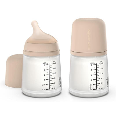 Suavinex 2Pk Zero Zero anti-colic baby bottles in light tone with adaptable flow nipples and measurement markings.