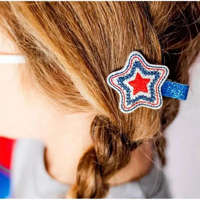 Star-shaped hair clip in red, white, and blue, worn in a braided hairstyle, celebrating 4th of July.