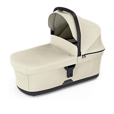 Soft beige Thule bassinet featuring a collapsible canopy and a secure harness for infant safety.