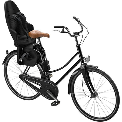 Thule Yepp 2 Maxi Frame Mount in Midnight Black attached to a bicycle, featuring a sturdy child seat with safety straps.